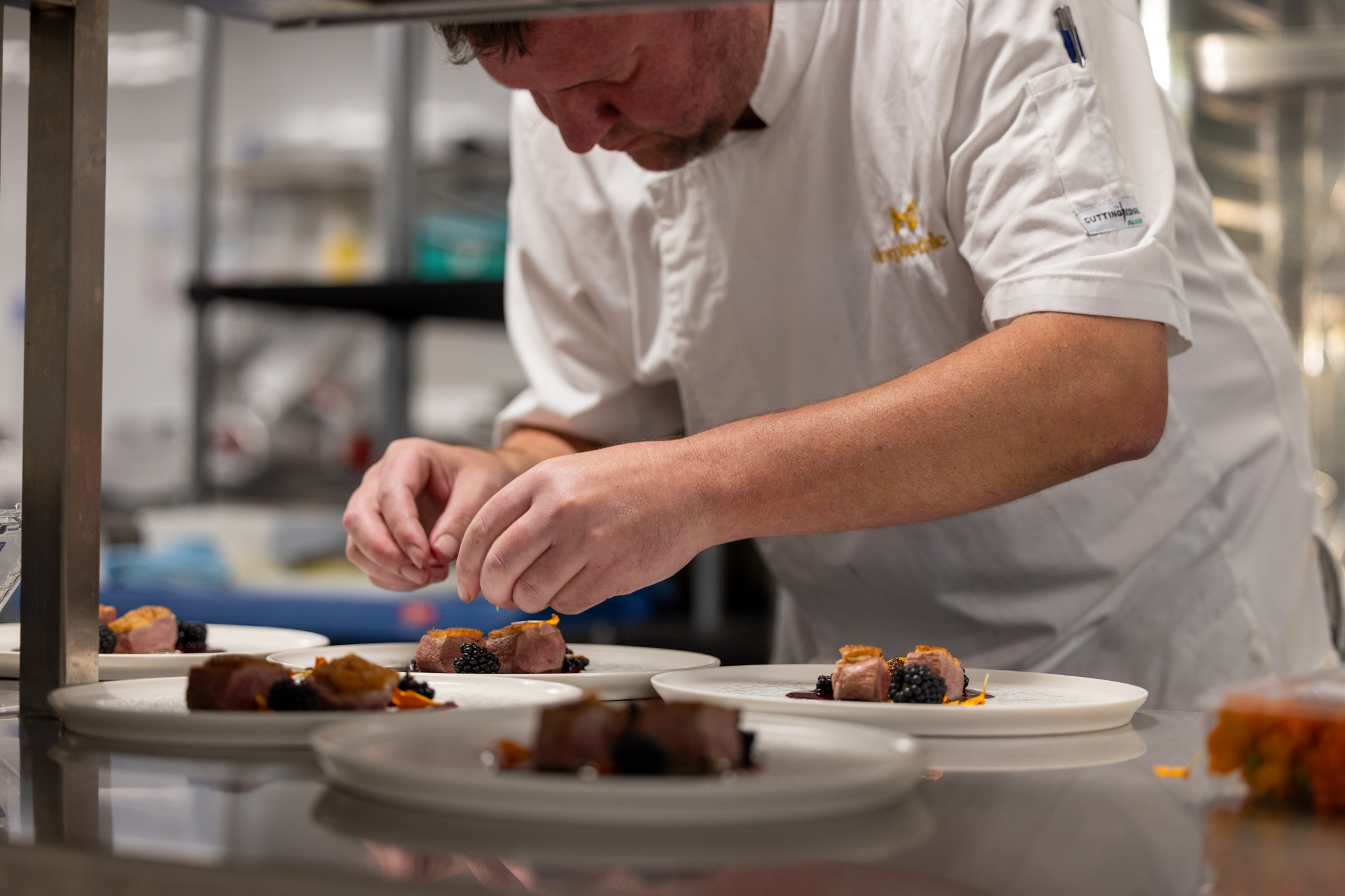 Morphettville Executive Chef, Steven Clark preparing putting the final touches on a meal.